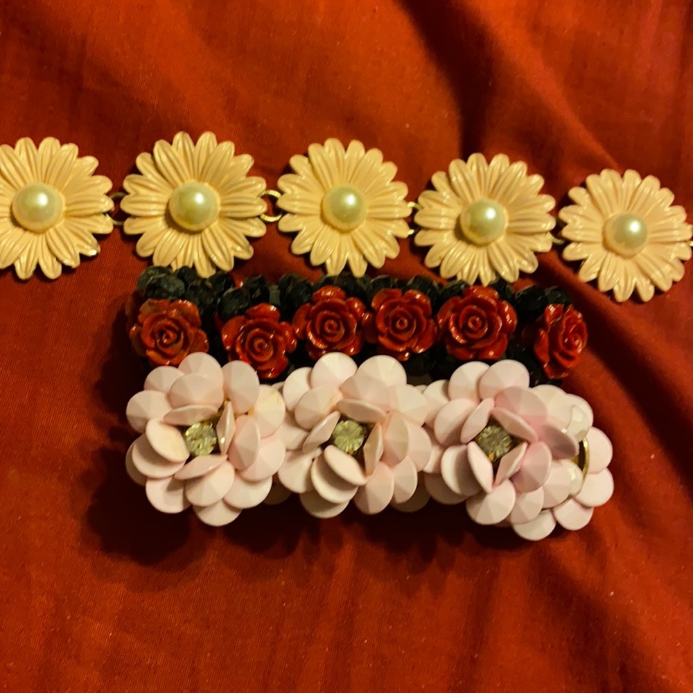 3 bracelets 2 with roses and 1 with daisies
